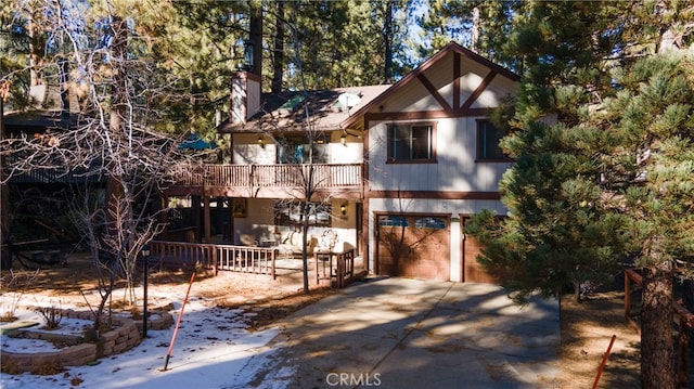 41984 Mapleleaf Dr, Big Bear Lake, CA 92315 - chalet / cabin featuring concrete driveway, a balcony, a carport, a chimney, and an attached garage