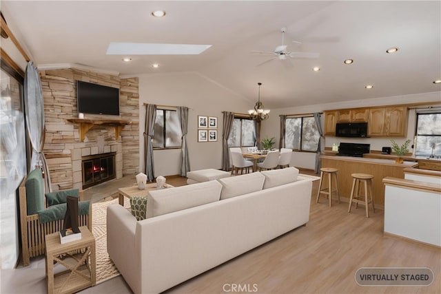 41984 Mapleleaf Dr, Big Bear Lake, CA 92315 - living area with healthy amount of natural light, ceiling fan, a fireplace, lofted ceiling, and light wood-style floors