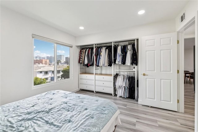 bedroom with a closet and light hardwood / wood-style floors