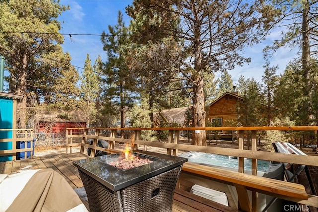 deck featuring a hot tub and a fire pit