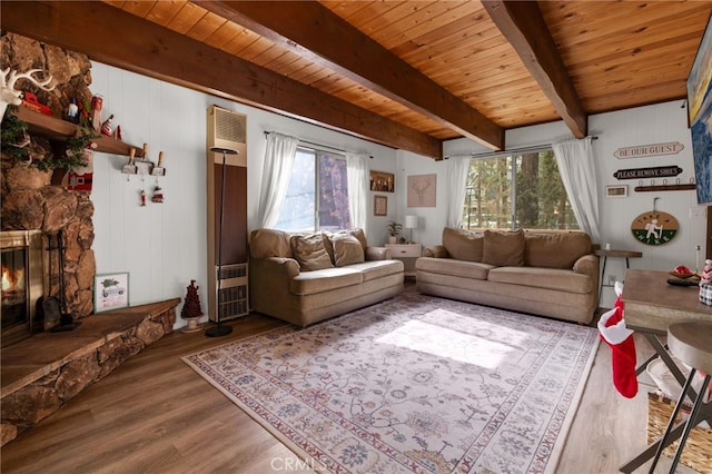 living area featuring wooden ceiling, a fireplace, beam ceiling, and wood finished floors