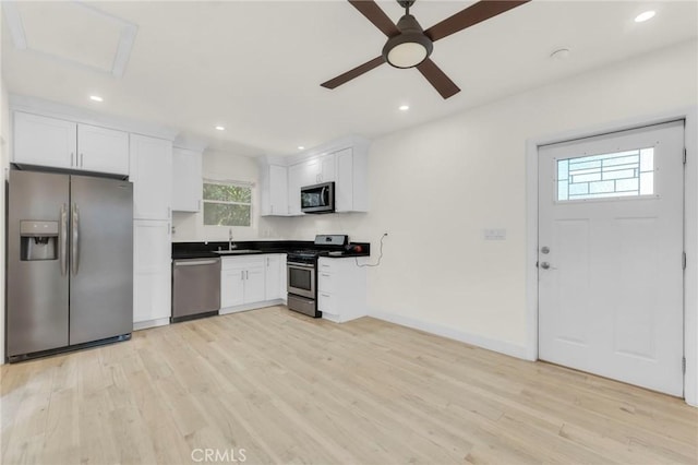 kitchen featuring white cabinets, stainless steel appliances, light hardwood / wood-style floors, sink, and ceiling fan