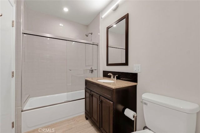 full bathroom with toilet, enclosed tub / shower combo, and vanity