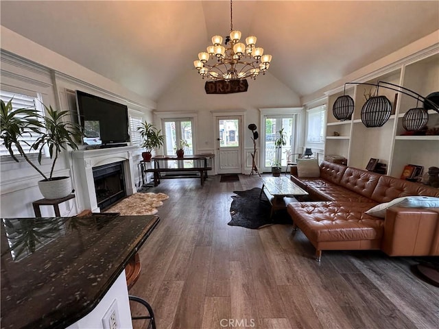 living room featuring plenty of natural light, dark hardwood / wood-style floors, a chandelier, and high vaulted ceiling