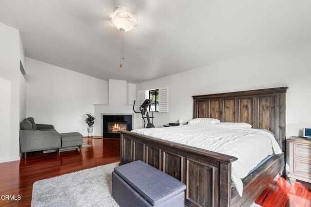 bedroom with dark wood-type flooring and a multi sided fireplace