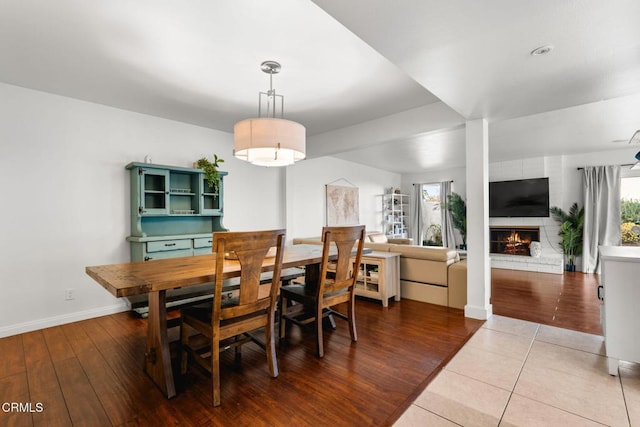 dining area featuring hardwood / wood-style flooring and a brick fireplace