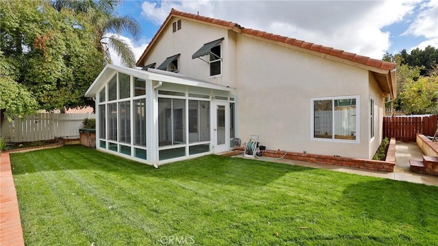 back of house with a yard and a sunroom