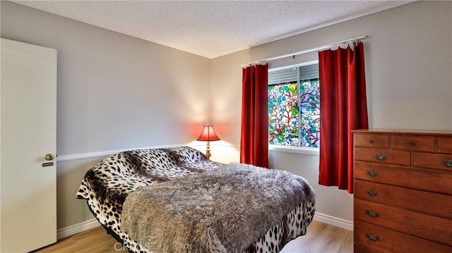 bedroom featuring a textured ceiling and light wood-type flooring