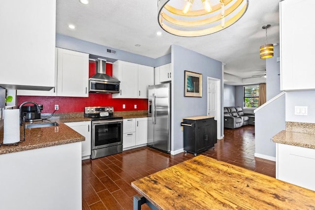 kitchen with white cabinetry, stainless steel appliances, sink, and wall chimney range hood