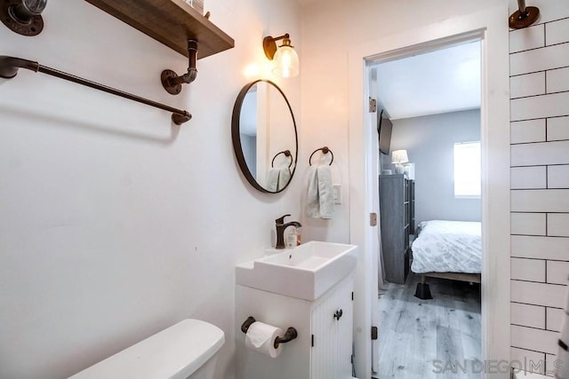 bathroom featuring wood-type flooring, vanity, and toilet