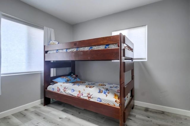 bedroom with light hardwood / wood-style floors and multiple windows