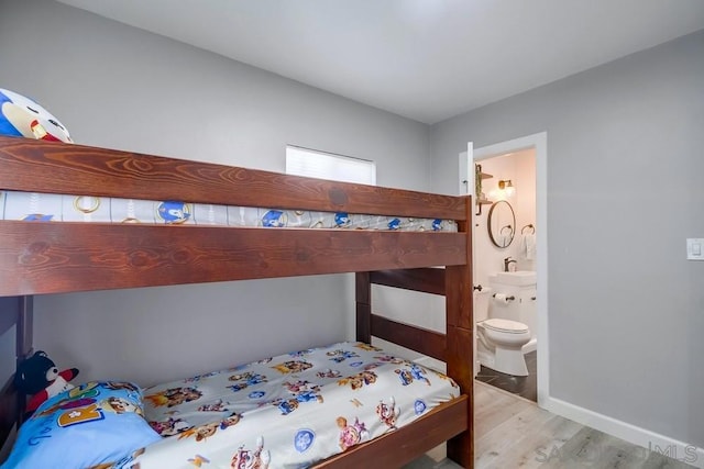 bedroom with ensuite bath and light hardwood / wood-style flooring