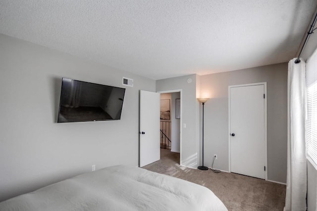 carpeted bedroom featuring a textured ceiling