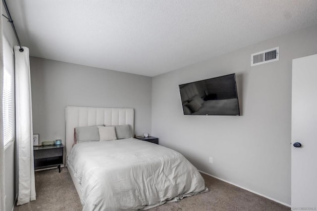 bedroom with a textured ceiling and carpet flooring