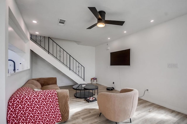 living room with ceiling fan and light hardwood / wood-style flooring