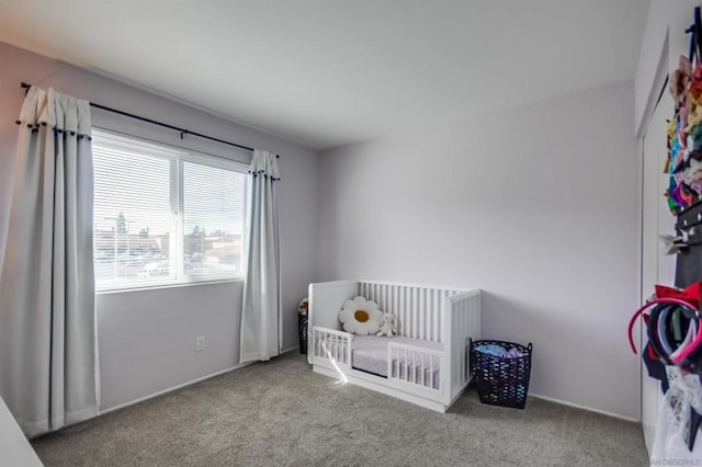 bedroom featuring light carpet and a crib