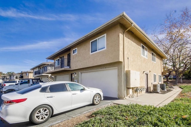 view of property exterior with central air condition unit and a garage