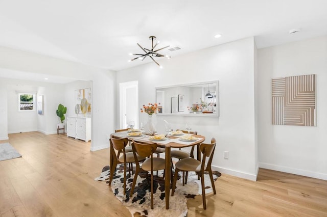 dining area featuring a notable chandelier and light hardwood / wood-style floors