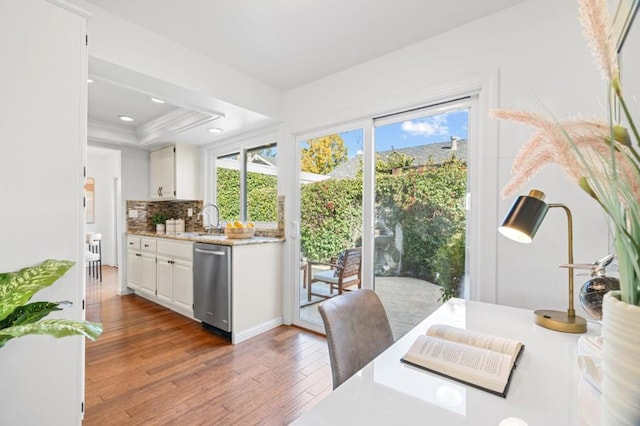 dining area featuring sink, a tray ceiling, dark hardwood / wood-style flooring, and crown molding