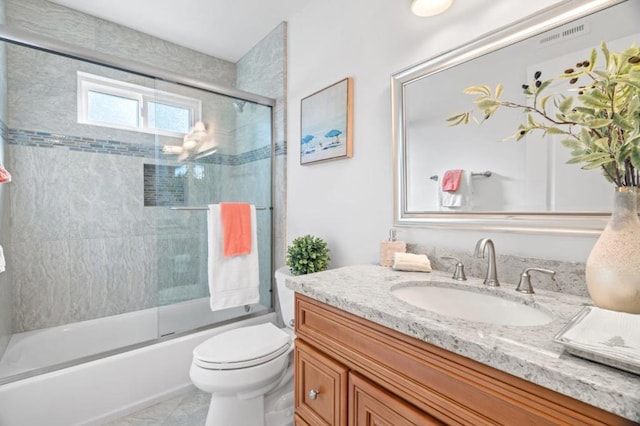 full bathroom featuring bath / shower combo with glass door, toilet, tile patterned floors, and vanity