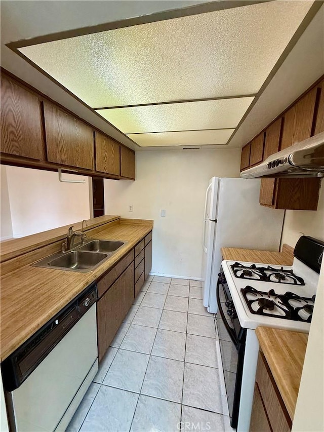 kitchen with white dishwasher, sink, range with gas cooktop, and light tile patterned floors