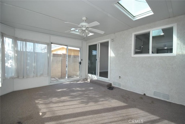 unfurnished sunroom featuring a skylight and ceiling fan