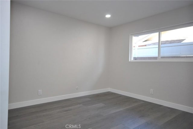 unfurnished room with dark wood-type flooring