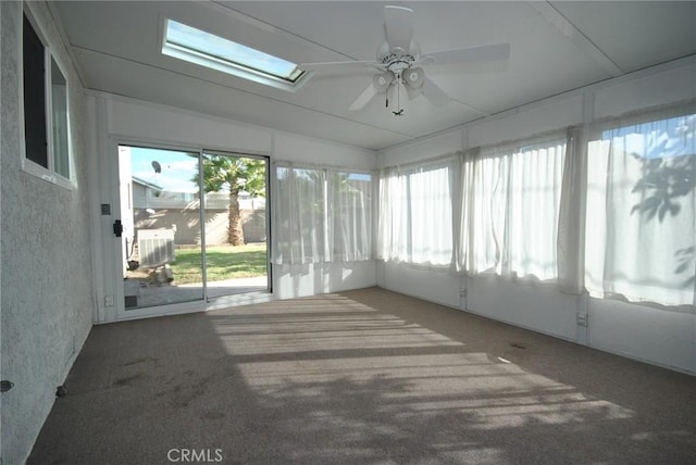 unfurnished sunroom with ceiling fan, a skylight, and a wealth of natural light