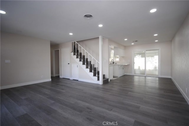 unfurnished living room with dark wood-type flooring and sink