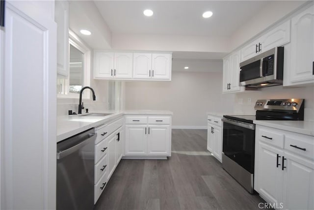 kitchen featuring sink, white cabinets, dark wood-type flooring, and appliances with stainless steel finishes