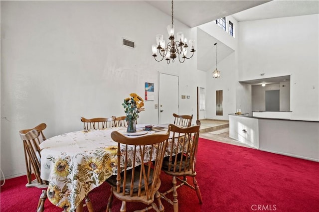 dining room featuring a notable chandelier, a towering ceiling, and carpet flooring