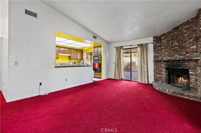 unfurnished living room with a fireplace, carpet floors, and vaulted ceiling