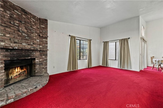 unfurnished living room with carpet floors and a fireplace