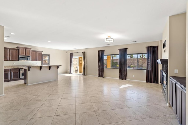 interior space featuring light tile patterned floors, a breakfast bar area, and a kitchen island