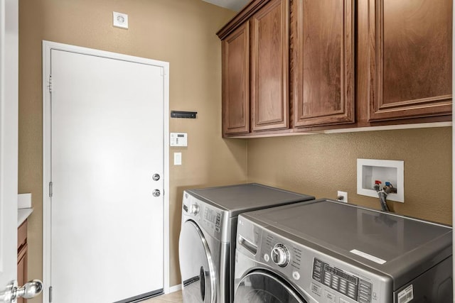 washroom with cabinets and washer and clothes dryer