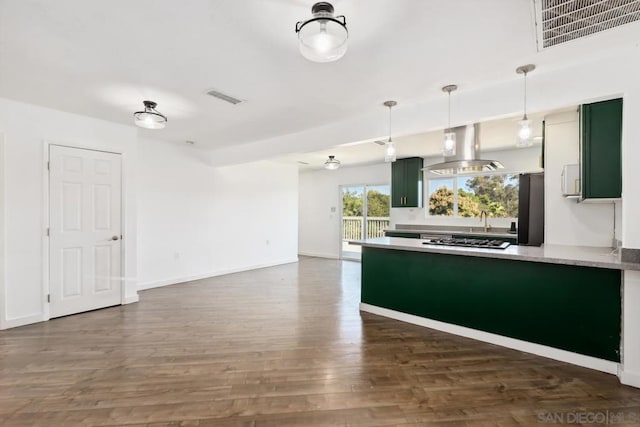 kitchen with green cabinets, hanging light fixtures, island exhaust hood, dark hardwood / wood-style floors, and stainless steel gas cooktop