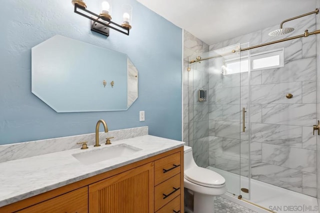 bathroom with vanity, a shower with shower door, and toilet