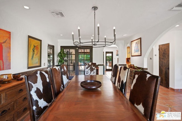 tiled dining area with an inviting chandelier and french doors