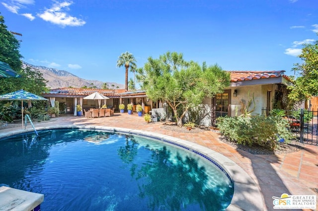 view of swimming pool with a mountain view and a patio area