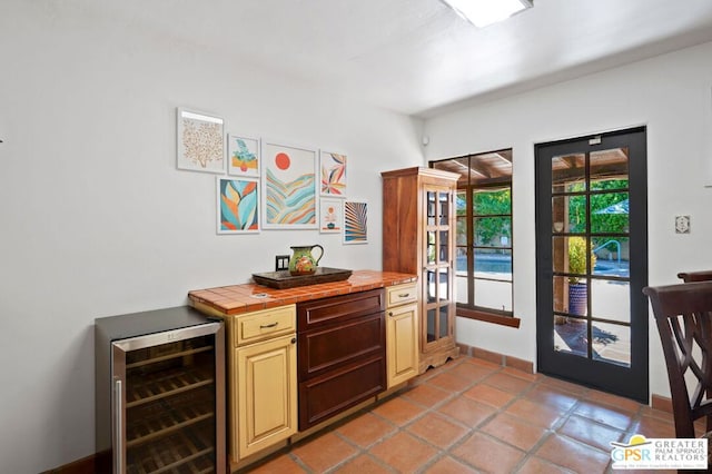 kitchen featuring tile countertops, light tile patterned floors, and beverage cooler