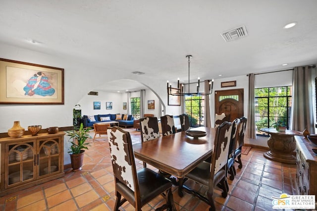 dining room with tile patterned floors and an inviting chandelier