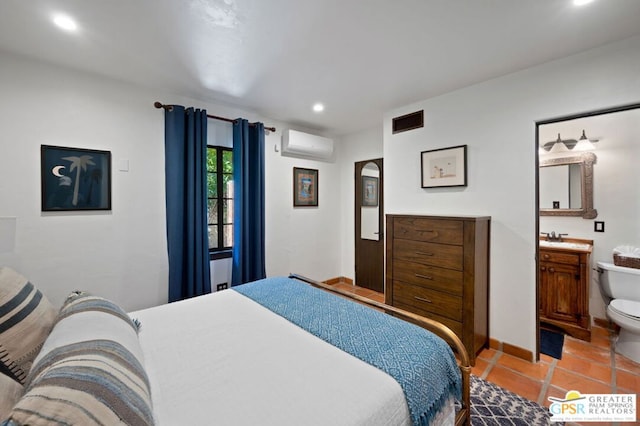 tiled bedroom featuring sink, ensuite bathroom, and a wall unit AC