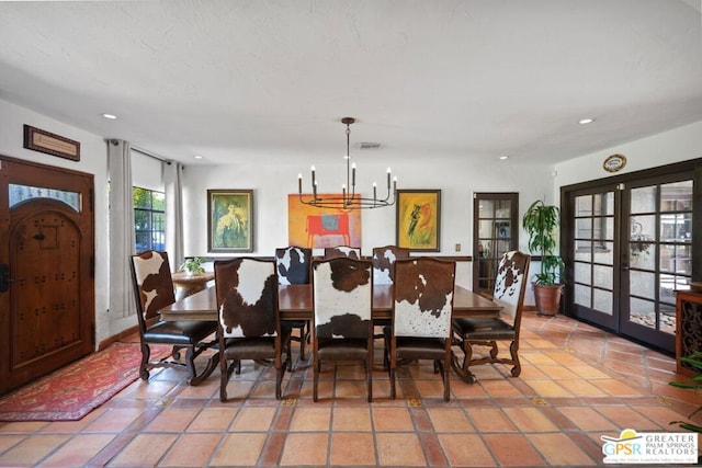 tiled dining room featuring a notable chandelier and french doors