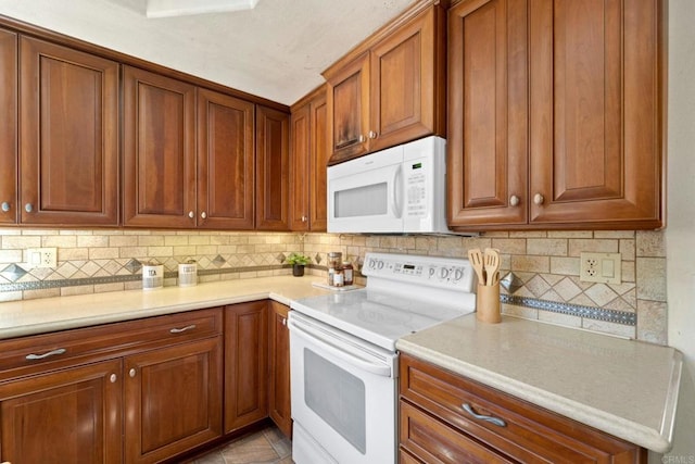 kitchen with white appliances, tasteful backsplash, and light tile patterned floors