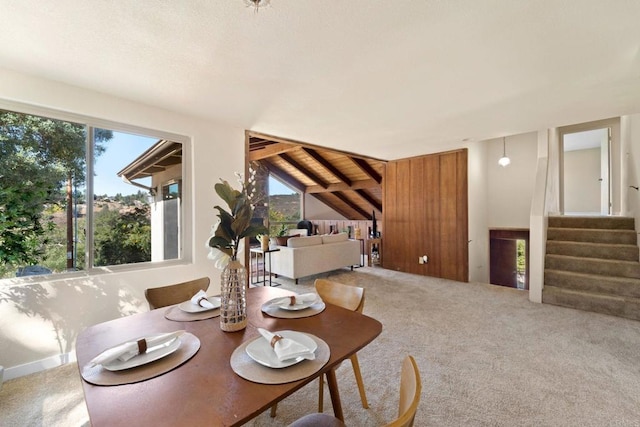 dining room with wood ceiling, carpet flooring, vaulted ceiling with beams, and plenty of natural light