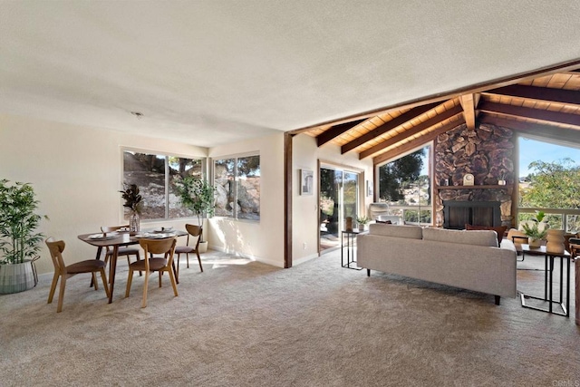 living room with carpet floors, vaulted ceiling with beams, a wealth of natural light, and wood ceiling