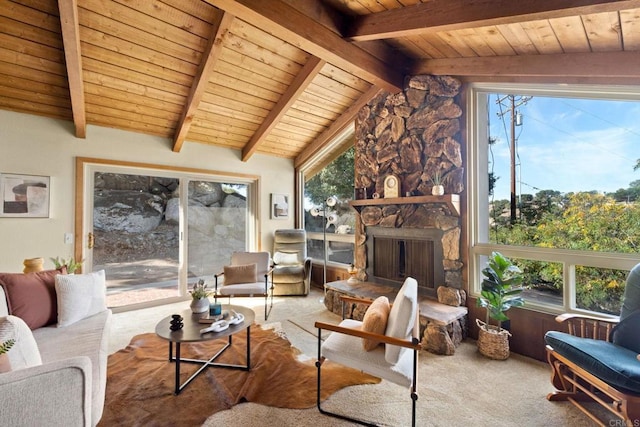 interior space with lofted ceiling with beams, a stone fireplace, and wood ceiling