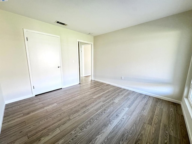 unfurnished bedroom with a closet and hardwood / wood-style flooring