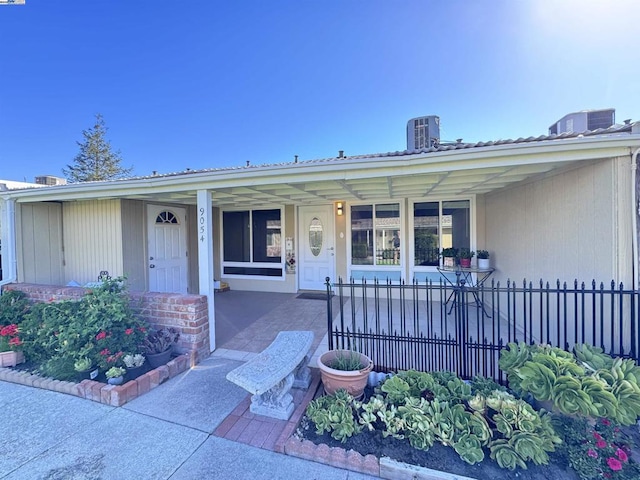 doorway to property with a porch and central air condition unit