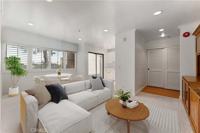 living area with baseboards, ornamental molding, and recessed lighting